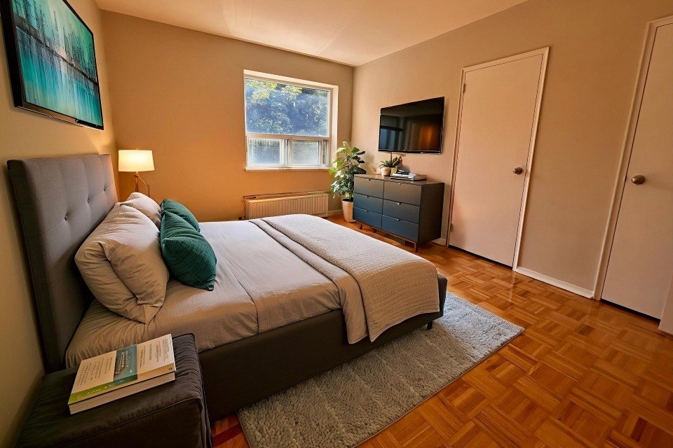 A bedroom with a bed, nightstand, and lamp.
