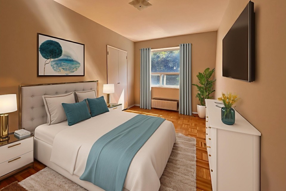 A bedroom with a large bed and a television on the wall.