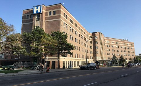 A hospital building with a blue letter H on top.