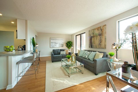 A living room with a grey couch and a glass coffee table.