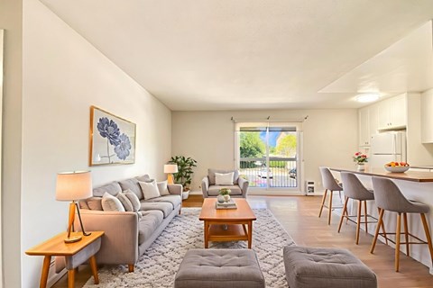 A living room with a grey sofa, a wooden coffee table, and a painting on the wall.
