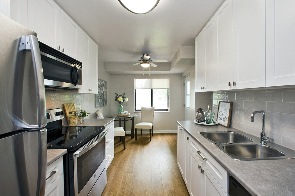 a kitchen with stainless steel appliances and white cabinets