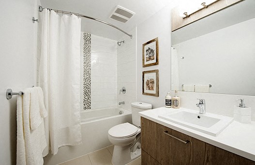 Full bathroom with wood cabinets and white counters