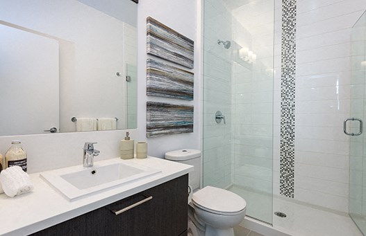 Full bathroom with black cabinets and white counters 