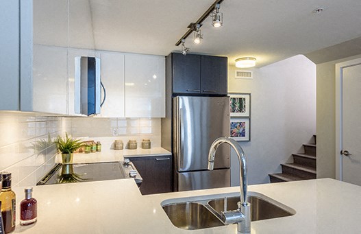 Spotless kitchen with white accents and pictures beside the fridge