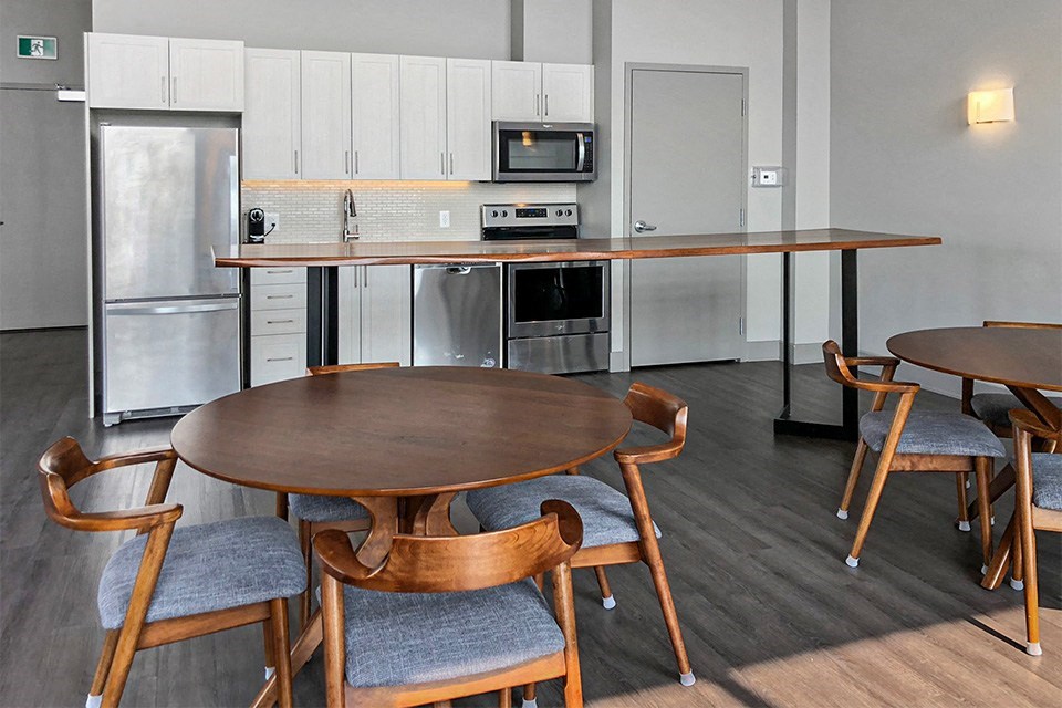 Social room  with kitchen and dining area, a table and chairs at Nuovo Apartments  in Ottawa, ON
