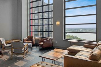 a living room with couches and chairs and large windows