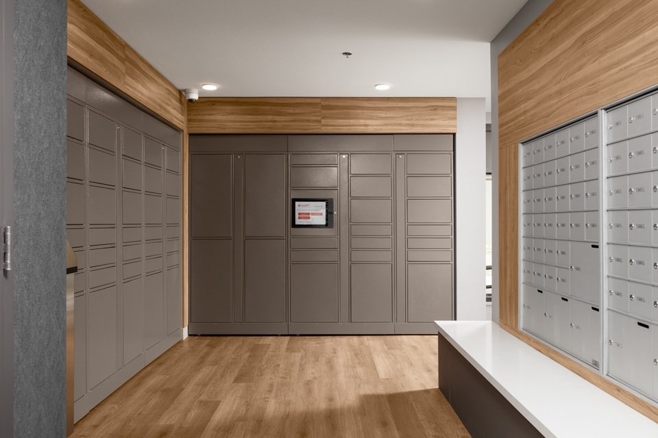 A hallway with a row of mailboxes on the right side.