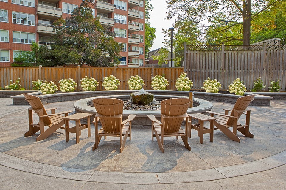 a patio with a fire pit and chairs