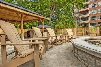an outdoor patio with chairs and tables and a fire pit