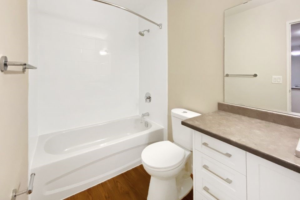 A white toilet sits next to a bathtub in a bathroom.