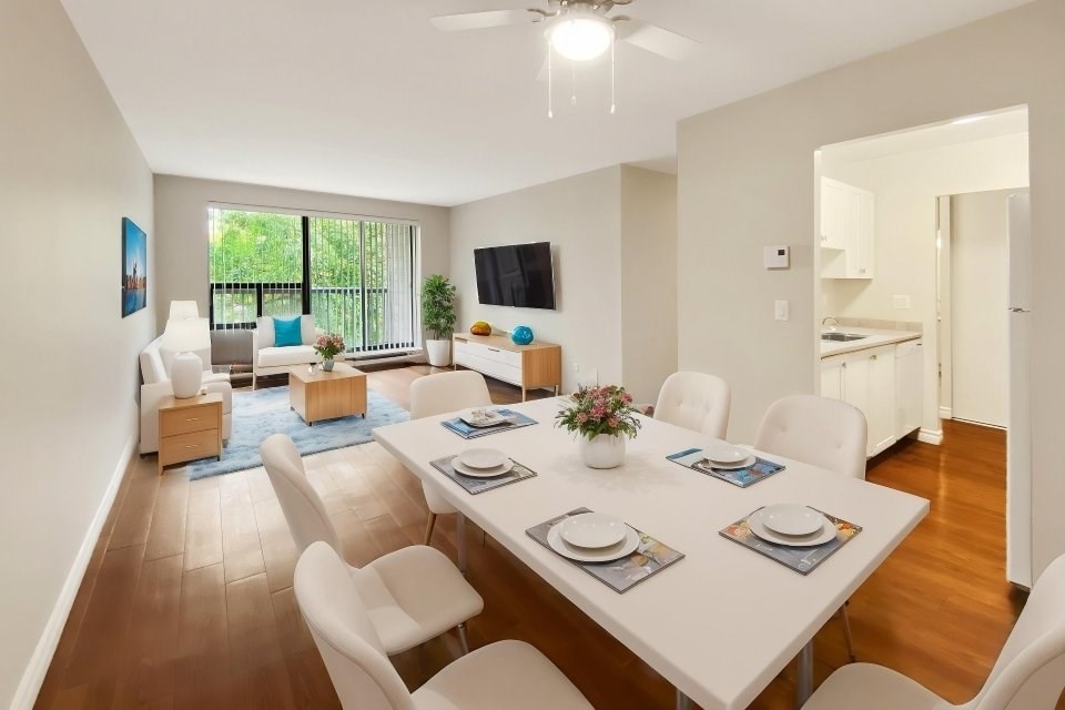A dining room with a white table and chairs.