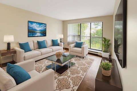A living room with a white couch, a glass coffee table, and a painting on the wall.