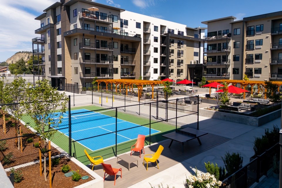 A pickleball court surrounded by chairs and umbrellas at The Ambrosi in Kelowna, BC.