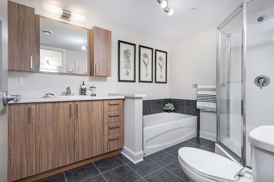 Large bathroom with bathtub and standing shower at Axial Towers
