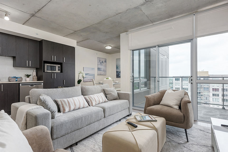 Brightly lit living room with access to private balcony at Axial Towers