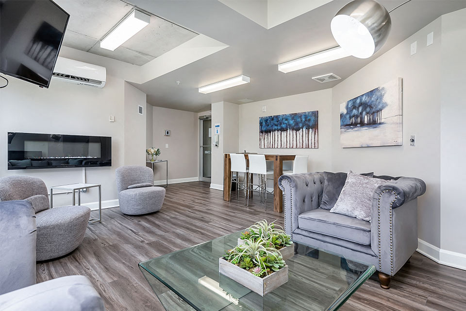 Social room with fireplace and dining table at Axial Towers