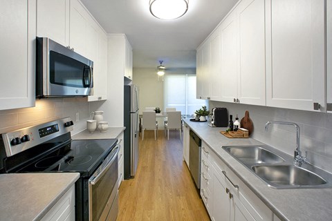 a kitchen with stainless steel appliances and white cabinets