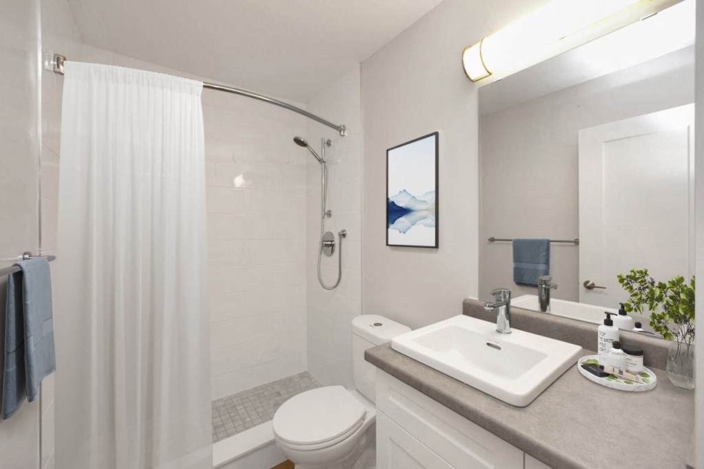 Bathroom with walk-in shower, toilet and vanity with top-mount sink at Riverbend Tower Apartments in Chatham, ON