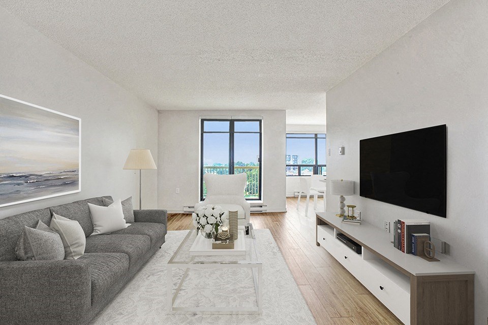 Living room, looking towards patio door and balcony, with couch, table and flat-screen tv