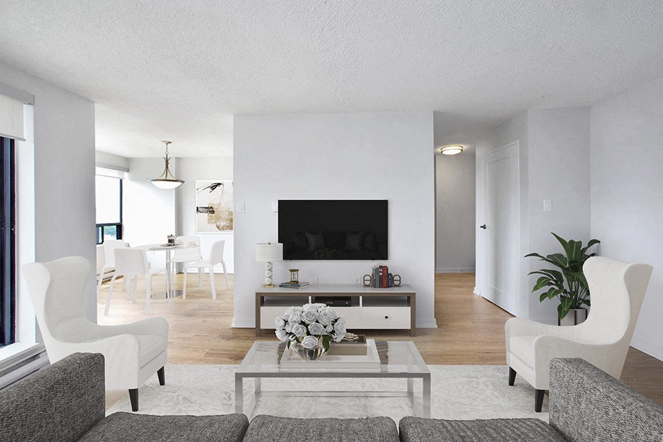 Living room at Riverbend Tower Apartments in Chatham, ON, looking towards TV with dining area in the left background