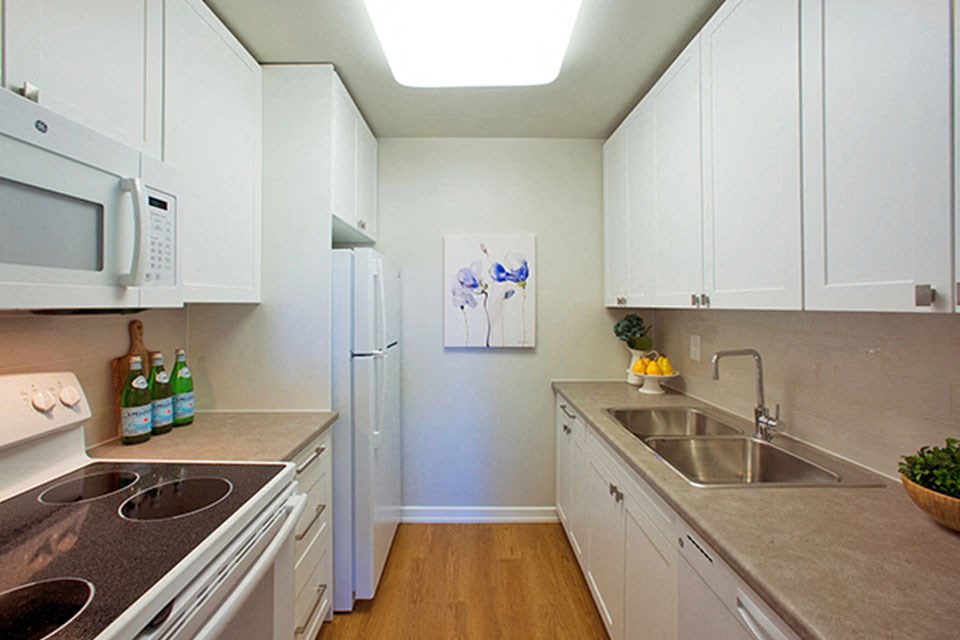 Shannon Towers in Collingwood, ON kitchen with white cabinetry, full range stove, and fridge