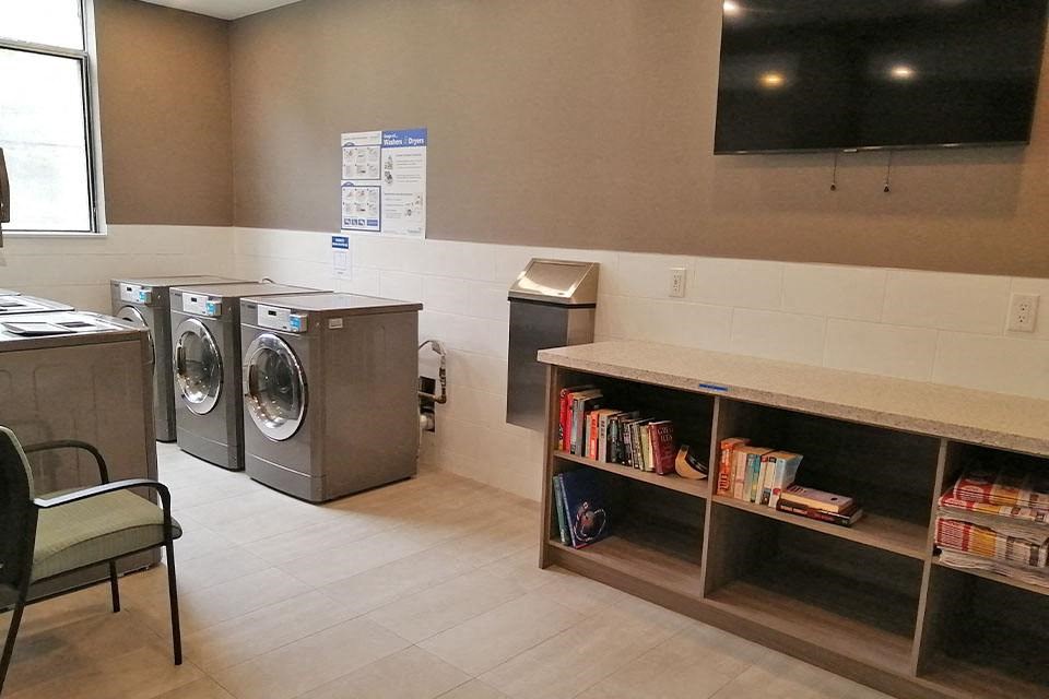 Silvercreek Towers in Georgetown, ON laundry facility with book shelf and TV