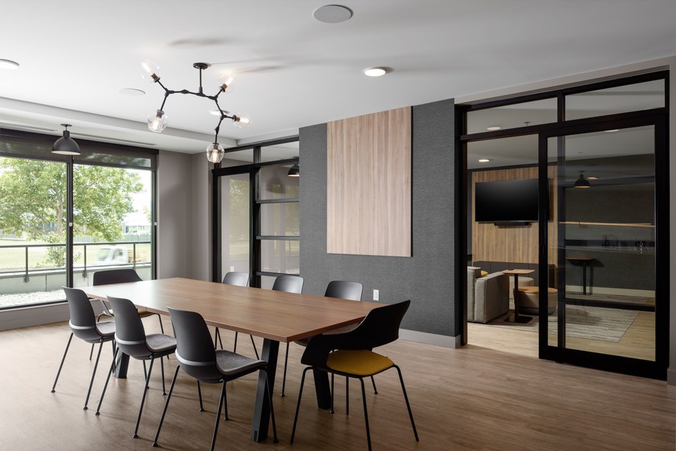 A conference room with a long table and chairs at The Ambrosi in Kelowna, BC.