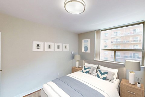 A bedroom with a large bed and a window in a renovated 2 bed 1.5 bath suite at Somerset Place in London, ON.