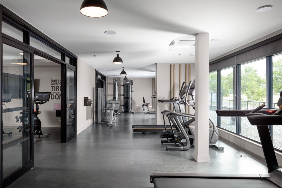 A gym with treadmills, weights, and exercise equipment.