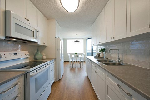A kitchen with white cabinets and stainless steel appliances.