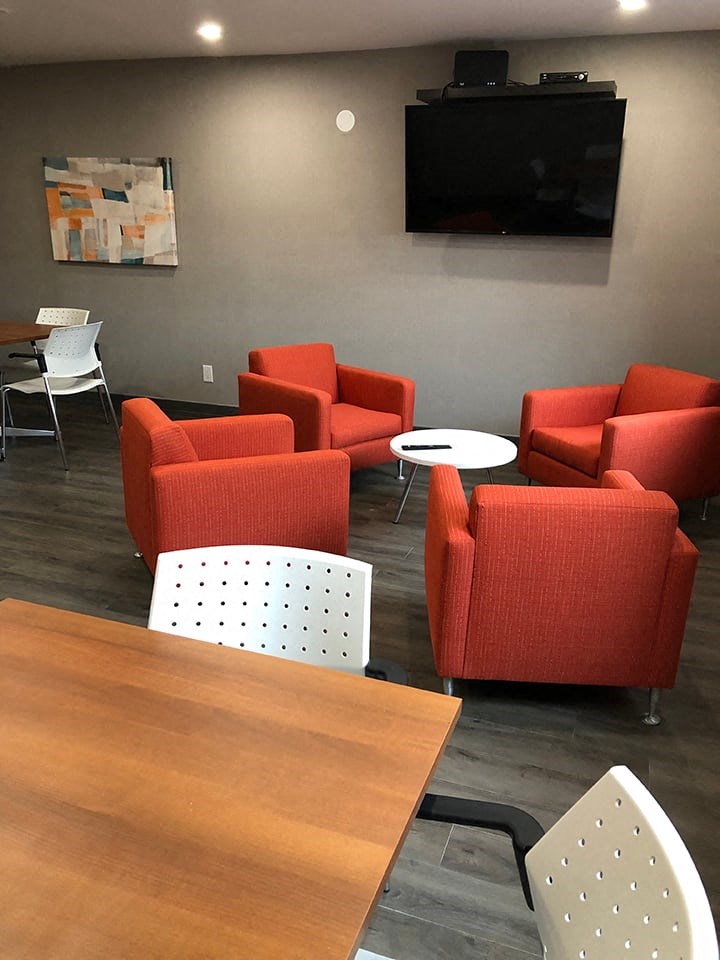 St. Augustine Place social room with comfy chair seating and a tv in St. Catharines, ON