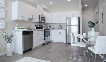 a kitchen with white cabinets and stainless steel appliances