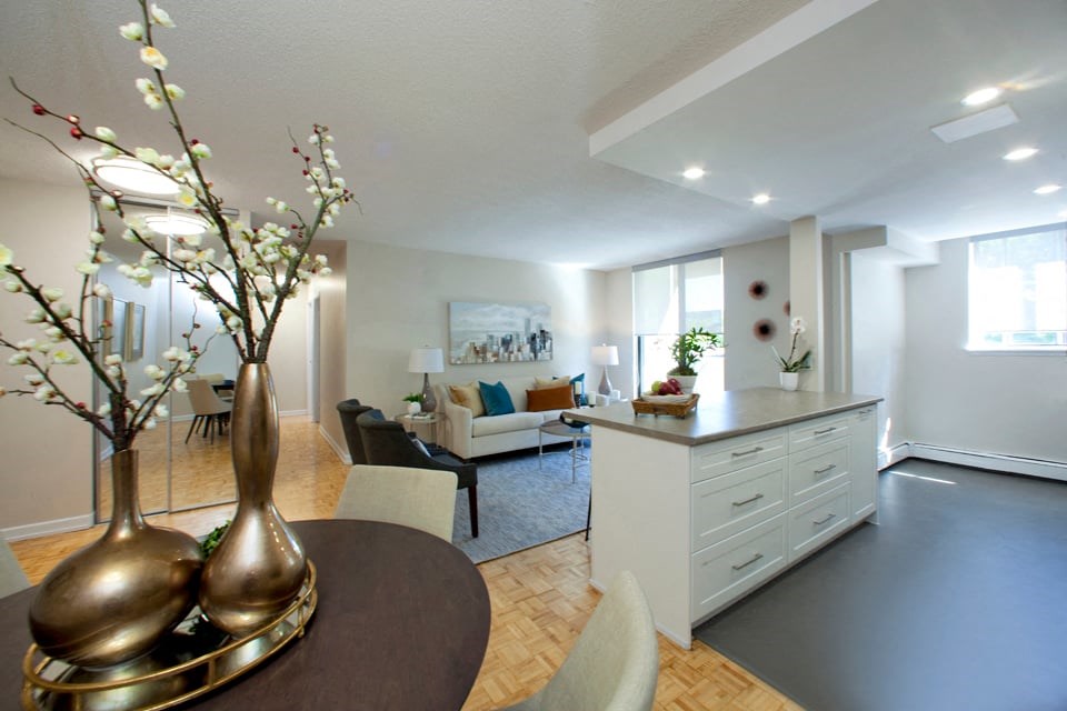 Bronze flower pots with pussy willow's inside. Open concept view of the kitchen and living room with no walls.