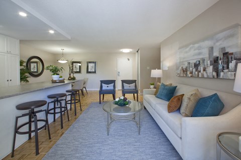 A living room with a white couch and a bar area.