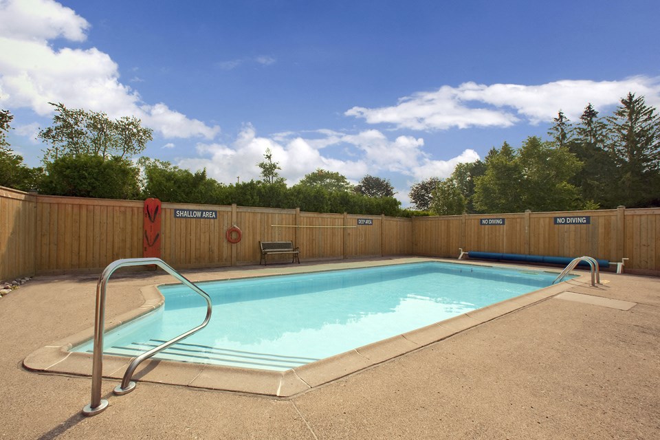 Sunset Towers outdoor pool with full-enclosed wood fence in St. Thomas, ON