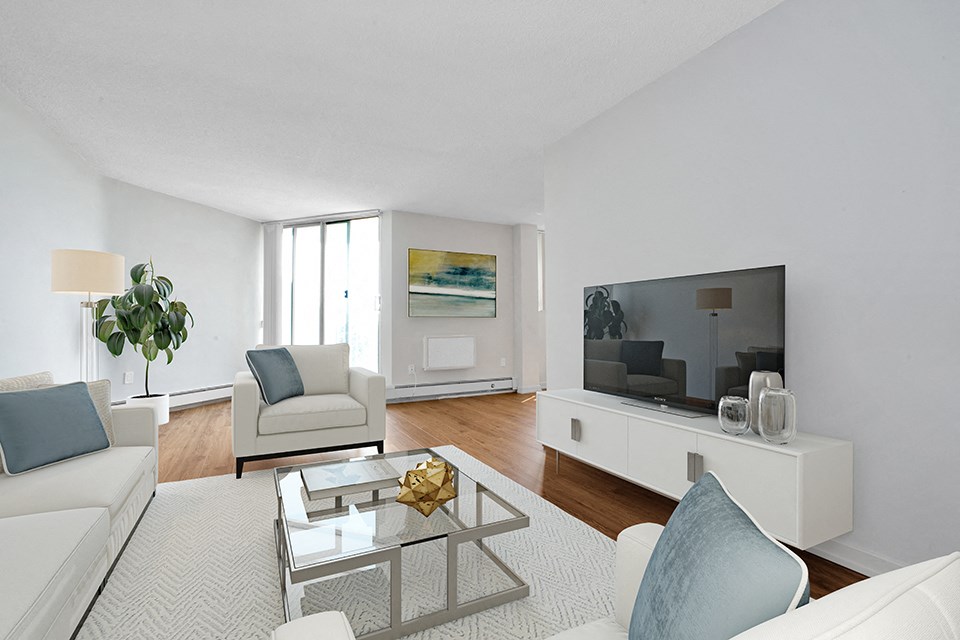 Sunset Towers Living Room with TV and entertainment unit, and balcony and sliding glass door in background in St. Thomas, ON