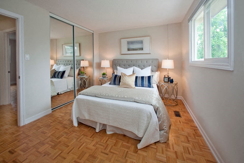 Tamarack Woods Bedroom with mirrored door closet and natural lighting through large windows in Barrie, ON