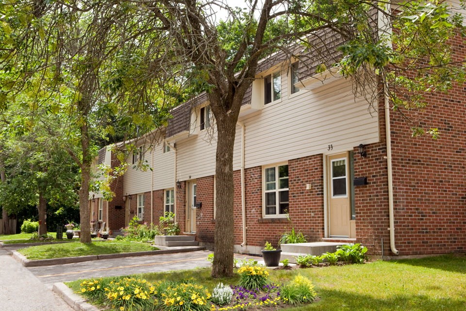 Tamarack Woods Several townhouse exteriors next to each other with neatly clipped green grass and lush trees in Barrie, ON