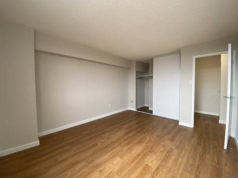 Primary bedroom in a two bedroom suite looking towards closet and bedroom door at Tarawood Place in Peterborough, ON