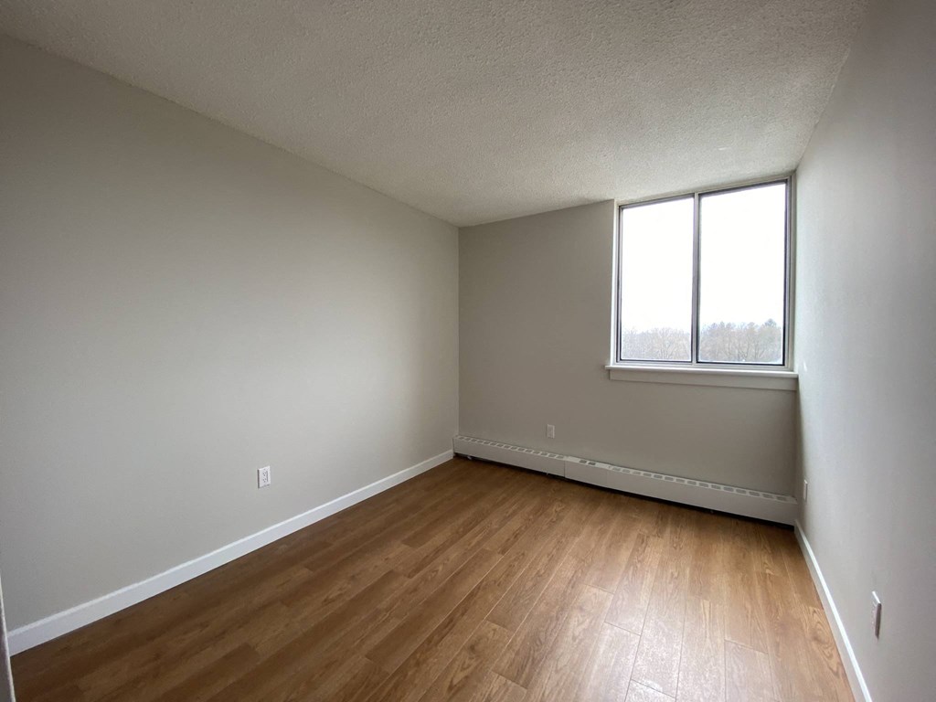 Second bedroom in a two bedroom apartment looking towards sliding glass window at Tarawood Place in Peterborough, ON