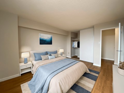 A bedroom with a bed, nightstands, and a window in Peterborough ON