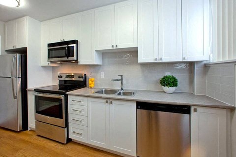 a kitchen with stainless steel appliances and white cabinets