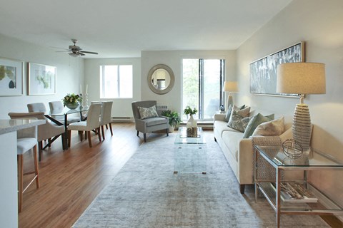 A well-lit, spacious living room with a variety of furniture and decor.