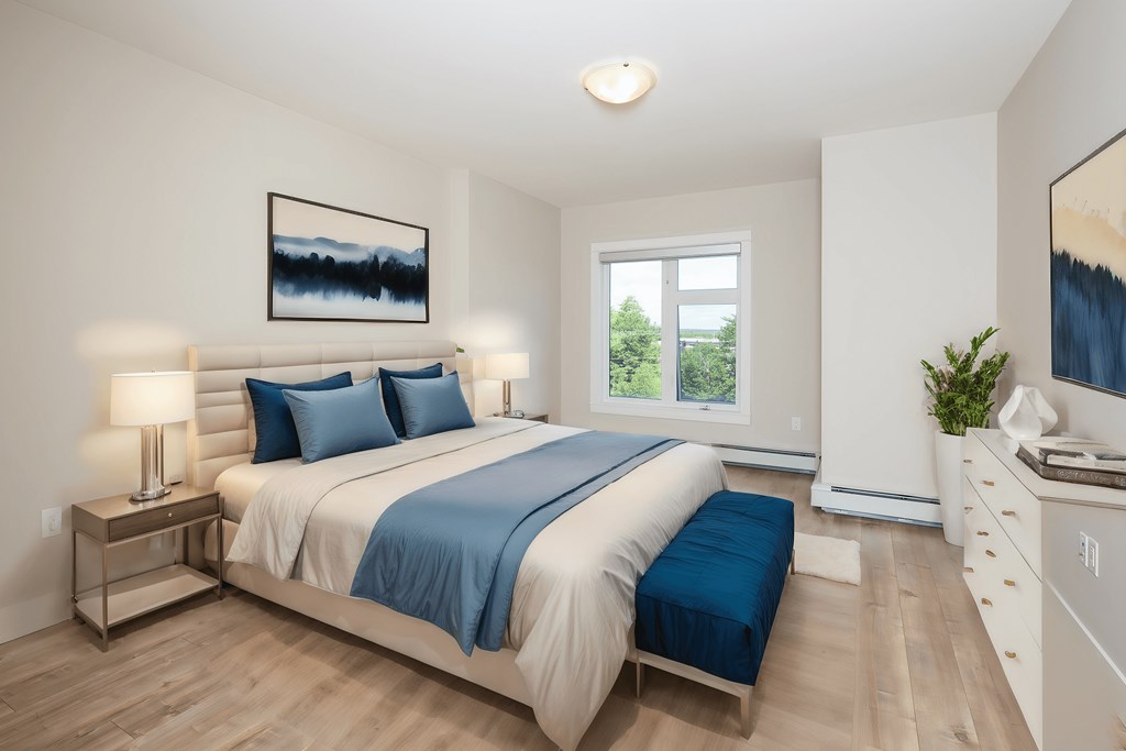 a bedroom with white walls and a bed with blue pillows