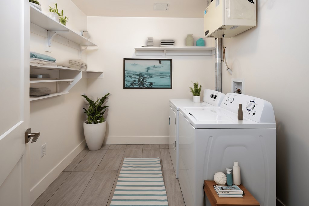 a small white laundry room with a sink and a washing machine