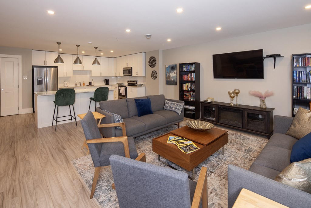 a living room with couches and chairs and a kitchen