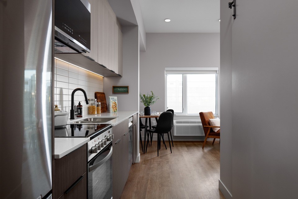 A modern kitchen with a dining table and chairs.