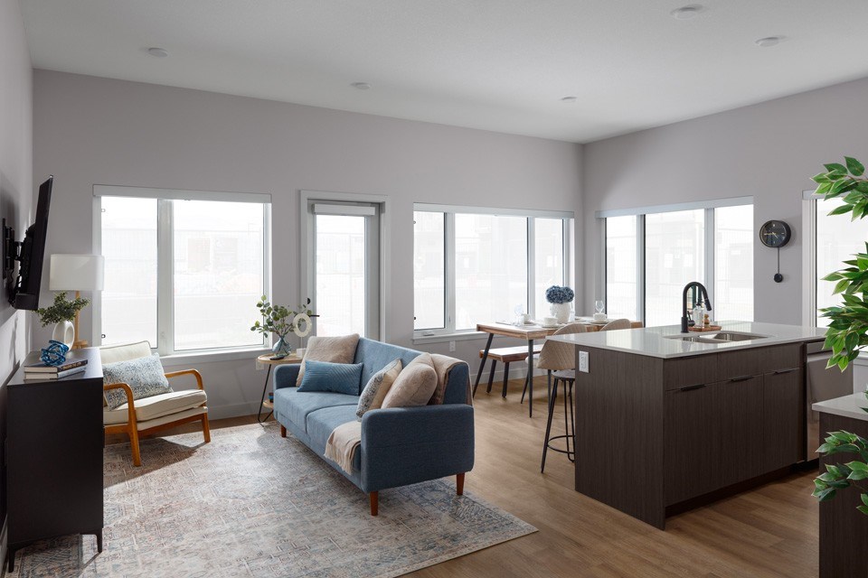 A living room with a blue couch and wooden floors.