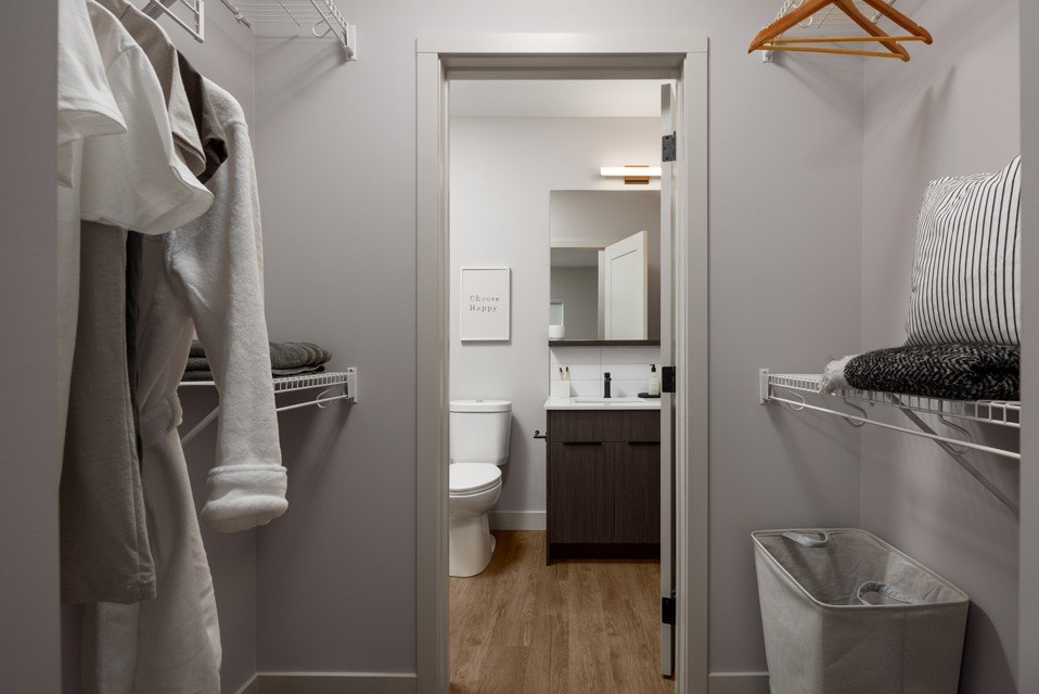 A small, white bathroom with a towel rack and a toilet at The Ambrosi in Kelowna, BC.